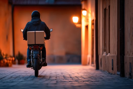A person riding a motorcycle with a box on the back photo
