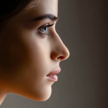 A woman with a blue eye is looking off to the side photo
