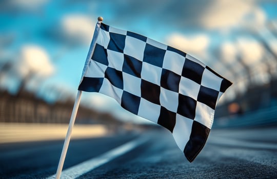 Checkered Flag Positioned at Racetrack Signaling End of Race During Afternoon Light photo