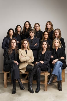 Group portrait of eleven women sitting on a bench indoors photo