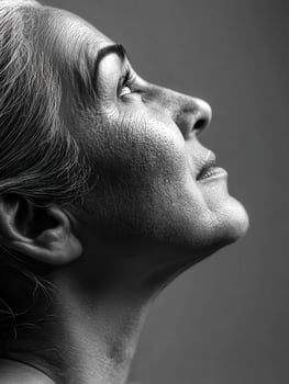 Side profile of mature woman looking upward in studio photo