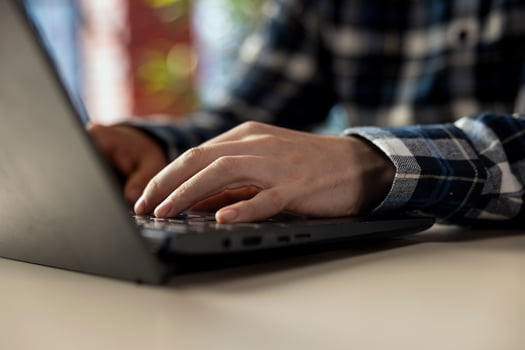 Worker at home office desk editing documents on notebook, updating reports and files, typing text. Close up of employee managing digital documents within file directories on laptop photo