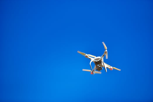 Modern Drone with camera flying on blue sky photo