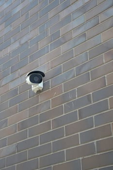 Outdoor security camera mounted on a brick wall photo