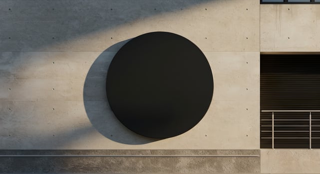 Blank black circular billboard on concrete wall with soft shadows. photo