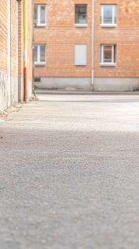 Urban Alleyway with Brick Building Facade and Textured Ground, Capturing Quiet City Life and Architectural Details photo
