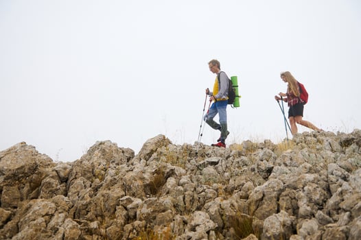 Hikers Exploring Rocky Mountains in Misty Weather with Backpacks photo
