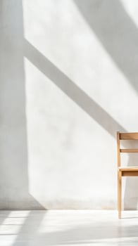 Minimalist Interior with Natural Light and Shadows on a White Wall, Featuring a Simple Wooden Chair for a Serene and Modern Home Aesthetic. photo