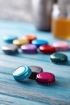 Colorful bottle caps create a cheerful vibe on blue wooden table photo