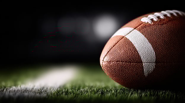 American football close up lying on green field photo