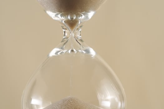A minimalist conceptual image of an hourglass to symbolize the passage of time, aging, and importance of skincare, balance photo