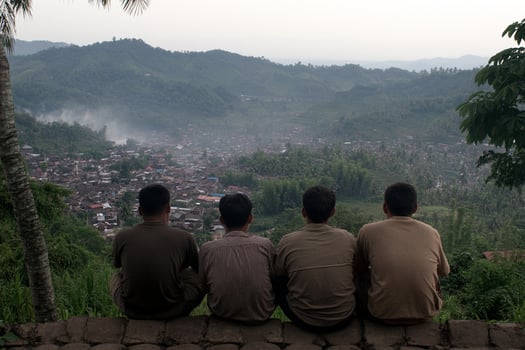 Three men sitting on a wall photo