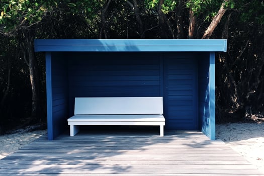 A blue bench sitting on a wooden deck photo
