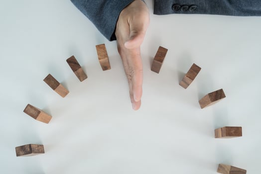insurance hand protect domino. Businessman hands stop dominoes falling in business crisis. business risk control and planning and strategies to run prevent insurance businesses. photo