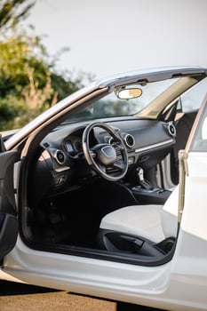 Interior of modern convertible car with driver's door open, featuring sleek steering wheel, detailed dashboard, and luxurious front seat. Highlights advanced design and comfort. photo