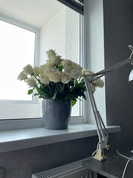 A vase of white flowers sitting on a counter photo