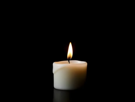 Single Lit Candle on Black Background A Symbol of Remembrance and Hope photo