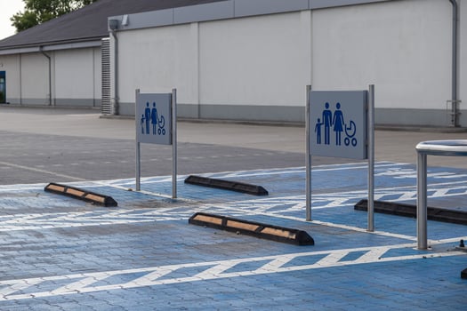 Spacious designated parking spots with blue ground markings and family stroller signs at an empty commercial supermarket lot, symbolizing convenient accessibility photo