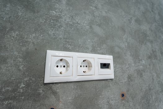 This Modern Electrical Outlet features Dual Sockets along with a convenient USB Port, elegantly installed on a sturdy Concrete Wall, perfect for enhancing your living or working space photo