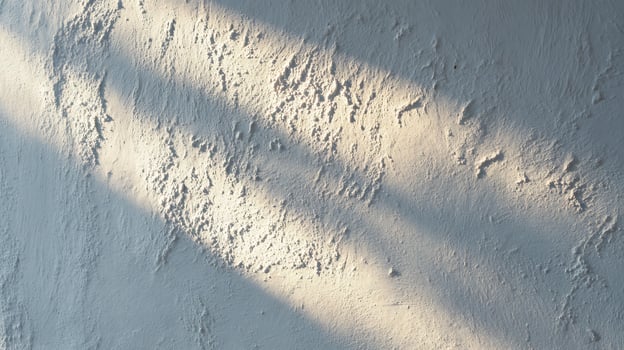 Rough white wall texture illuminated by warm sunlight and dark shadows. photo