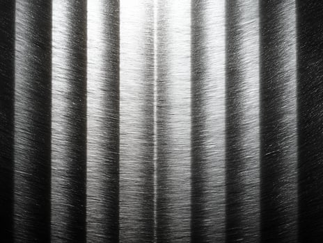 Textured silver gray metal background features vertical lines that create striking visual effect. interplay of light and shadow enhances metallic sheen, evoking sense of modernity photo