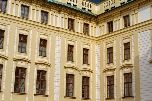 Discover the architectural beauty of a historic building in Prague. This facade features ornate windows and vibrant yellow walls, showcasing the city s rich design heritage. photo
