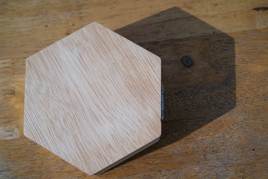 Top angle shot Hexagonal wooden jewelry box and shadow. Close-up of isolated hexagonal wooden box. Single objects. Texture and silhouette of jewelry box. Copy space. photo