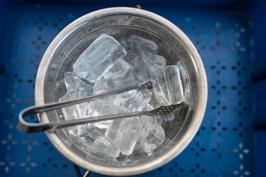 A shiny metal bucket filled with clear ice cubes photo