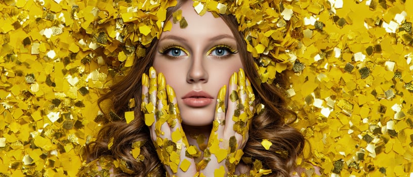 A woman with yellow hair and gold confetti on her face photo