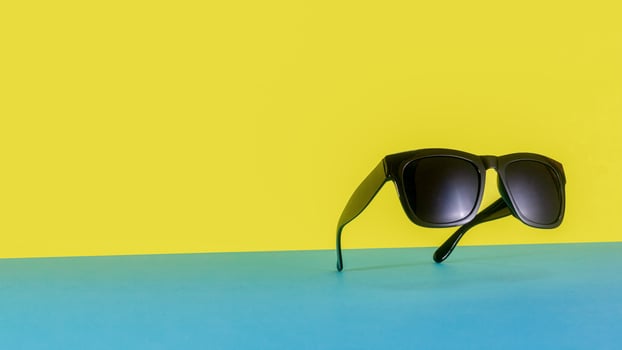 Suspended Sunglasses on Colorful Blue and Yellow Background photo