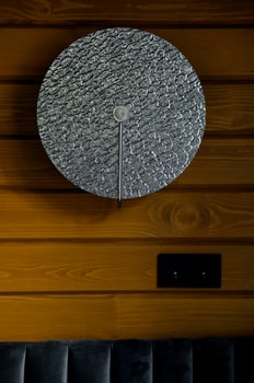 Stylish round gray clock on a wooden wall photo
