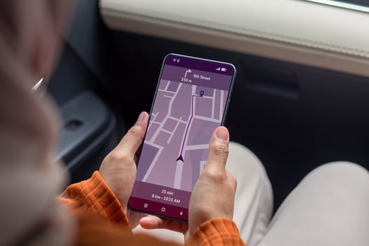 Woman in a car holding a mobile phone with a GPS navigation map. Travel with online map guide on smartphone. photo