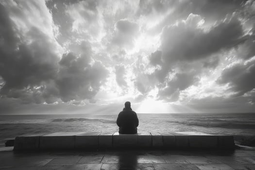 Man contemplating dramatic ocean view under cloudy sky photo