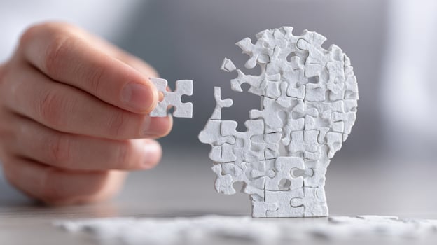 Hand placing puzzle piece in a jigsaw head photo