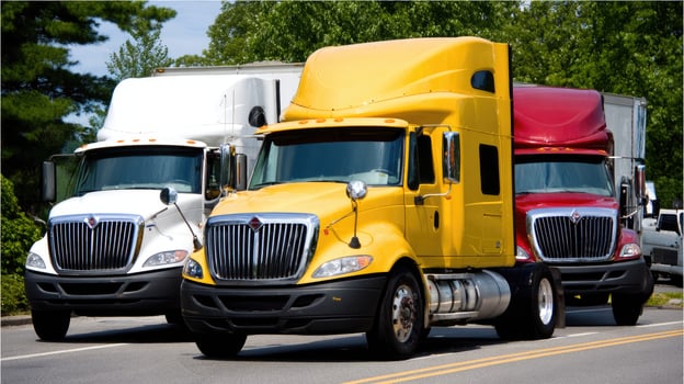 Three semi trucks are parked on the side of the road photo