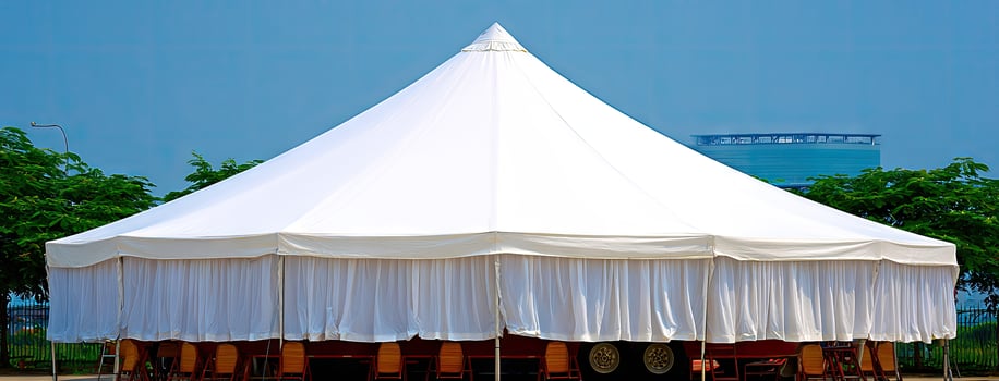 A white tent with a table and chairs photo