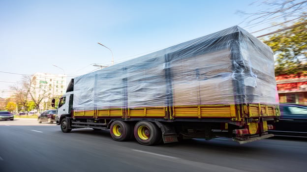 A truck is covered in plastic wrap on the side of the road photo