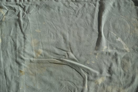Texture of an old dirty ragged cloth with brown stains. Dirty fabric photo