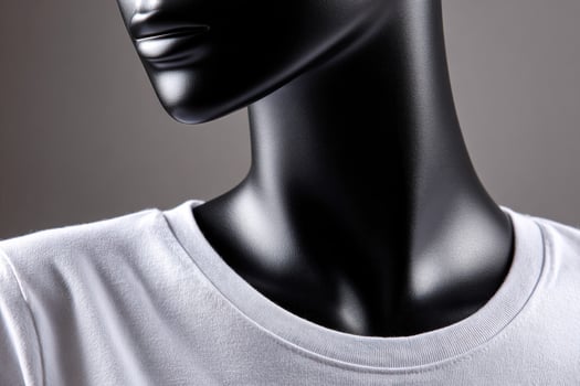 Black mannequin torso wearing a white t-shirt close up photo