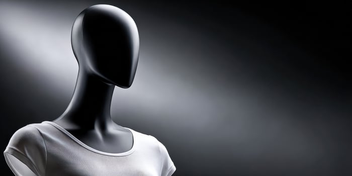 Black mannequin wearing a white shirt against dark gray photo