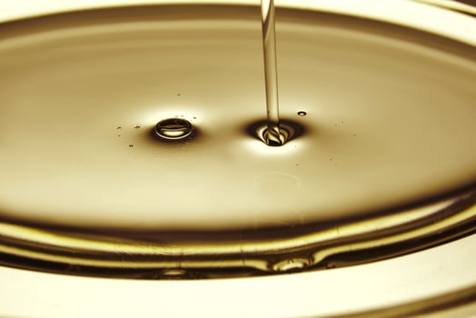 Pouring oil in golden tones. The texture of a cosmetic or other oil product. photo