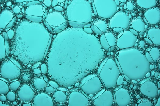 The texture of soap bubbles and foam in close-up on a green background. photo