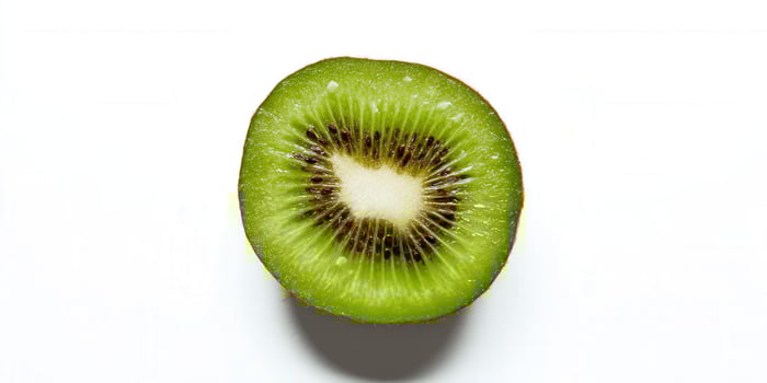 A close-up shot of a sliced kiwi fruit isolated on a white surface, highlighting its texture. photo