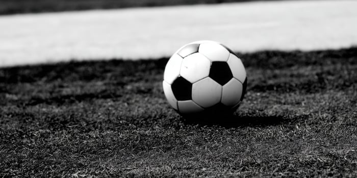 A black and white soccer ball rests on a field of green grass. photo