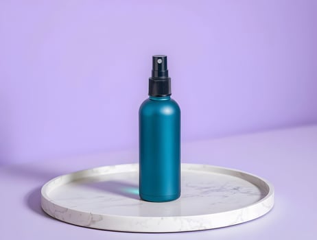 Blue bottle of spray on a white plate on a purple background photo