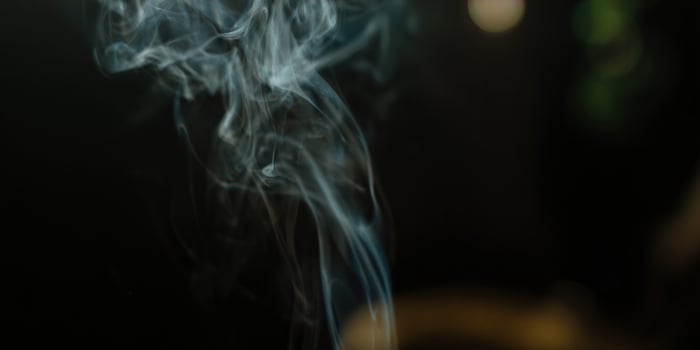 Abstract smoke rises, swirling and dancing against a dark background creating a moody visual. photo