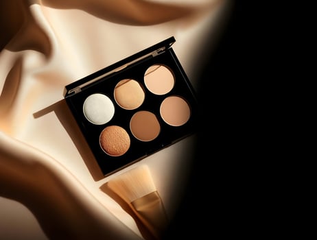 A makeup palette and brush on a silk sheet photo
