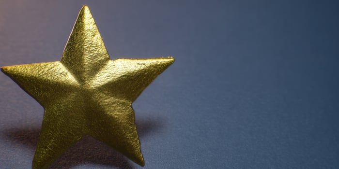 Close-up shot of a golden star against a deep blue backdrop, perfect for awards. photo