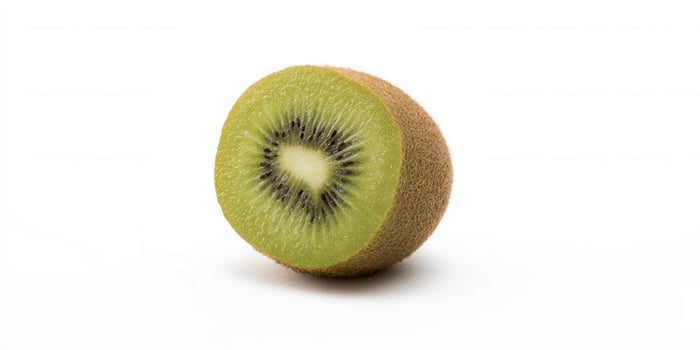 A perfectly sliced kiwi, showcasing its fresh and delicious qualities on a white surface. photo