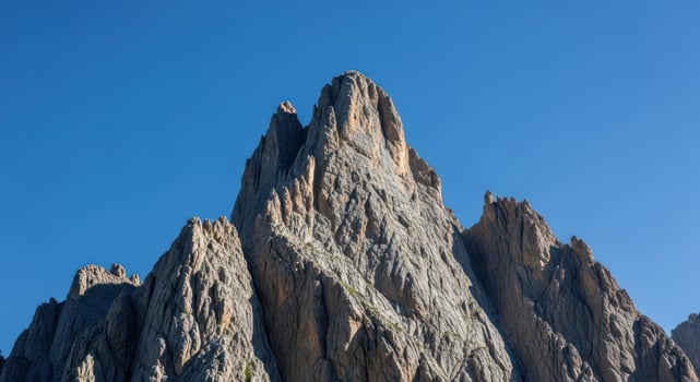 A rugged mountain peak against a clear blue sky photo